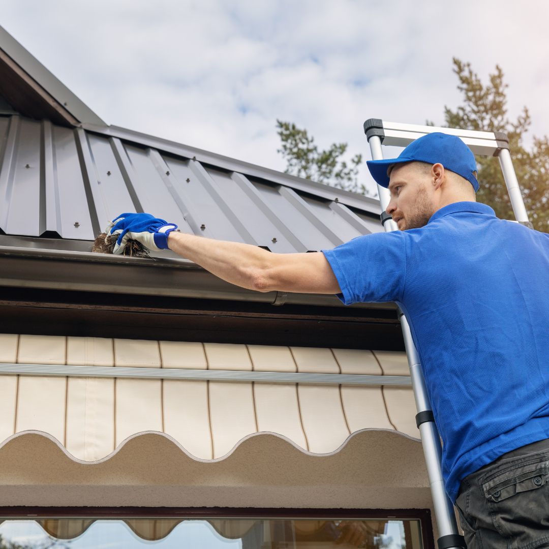 Man on ladder inspecting metal roof