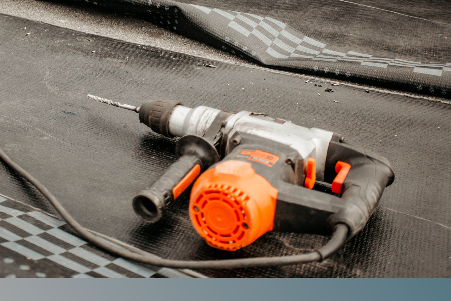 A drill lays on a roof