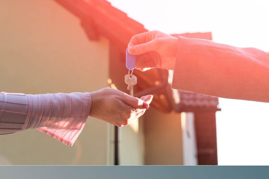 person hands house key to homeowner